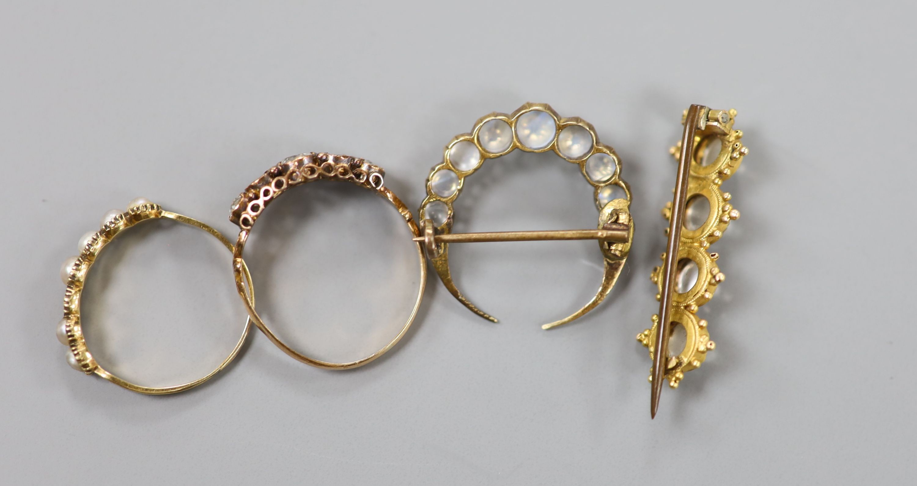 A Victorian 15ct gold and graduated aquamarine set half hoop ring, size O, gross 1.8 grams, a split pearl set ring(a.f.) and two antique yellow metal and moonstone set brooches, including crescent, gross 6.4 grams.